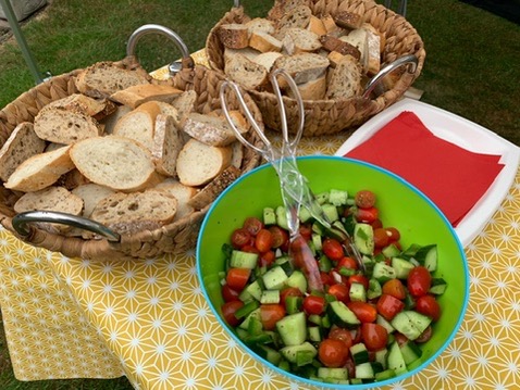 Baskets of bread and a bowl of Andalusian salad prepared by Big Pans People